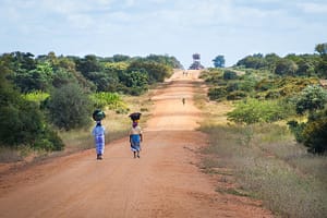 african women walking along road, sand road to mapai, african scene